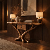 Console table with a natural edge top, small drawer unit and crossed branch legs in an evening entryway with walnut wall paneling