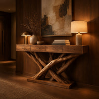 Console table with four slim drawers on a base of crossed tree branches in an evening entryway with walnut wall paneling