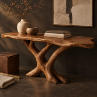 Corner detail of live edge console table with a base of crossed branch shaped legs beside wood, brass and linen samples