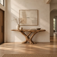 Live edge console table with a base of crossed branch shaped legs in a bright open plan entryway