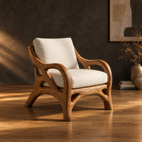 Lounge chair with a branch like wooden frame and soft cream cushions in a dark studio against a charcoal plaster wall
