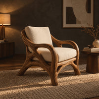 Lounge chair with a branch like wooden frame and soft cream cushions in a dark living room at golden hour