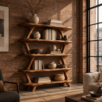 Bookshelf with five wide open shelves held by slim branch shaped uprights in an industrial loft living room with exposed brick