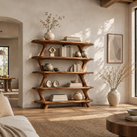Bookshelf with five wide open shelves held by slim branch shaped uprights in a bright open plan living room
