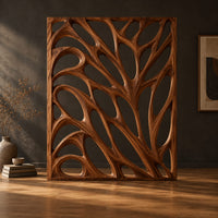 Tall room divider with sculpted open branch shaped cutouts in a dark studio against a charcoal plaster wall
