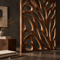 Corner detail of tall room divider with sculpted open branch shaped cutouts beside wood, brass and linen samples