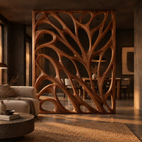 Tall room divider with sculpted open branch shaped cutouts in a dark open-plan living room at golden hour