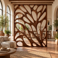 Tall room divider with sculpted open branch shaped cutouts in a bright open-plan living room with arched windows and plants