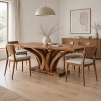 Rectangular dining table with a branching wood pedestal and thick slab top in a Scandinavian dining room with white walls