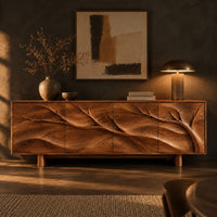 Carved branch sideboard with four flush panels and short cylindrical feet in a dark dining room at golden hour