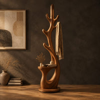 Branching floor lamp with a small shelf and a glowing trunk edge in a dark studio against a charcoal plaster wall