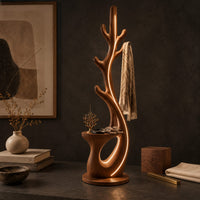 Corner detail of branching floor lamp with a small shelf and a glowing trunk edge beside wood, brass and linen samples