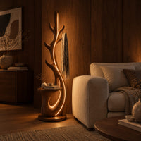 Branching floor lamp with a small shelf and a glowing trunk edge in an evening living room with walnut wall paneling