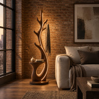 Branching floor lamp with a small shelf and a glowing trunk edge in an industrial loft living room with exposed brick