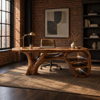 Sculpted wooden desk with branching legs and open shelves at one end in an industrial loft home office with exposed brick