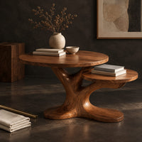Corner detail of coffee table with two tops on a branching tree shaped pedestal beside wood, brass and linen samples