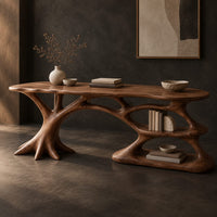 Corner detail of desk with branching root base, freeform top and open lower shelf beside wood, brass and linen samples