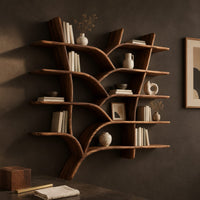 Corner detail of tree shaped shelves with curving branch supports and several wooden boards beside wood, brass and linen samples