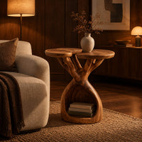 Side table with twin lobed tops on branching limbs above an open base in an evening living room with walnut wall paneling