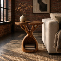 Side table with twin lobed tops on branching limbs above an open base in an industrial loft living room with exposed brick