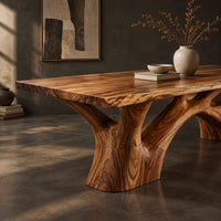 Corner detail of rectangular dining table with a slab top and branching trunk base beside wood, brass and linen samples