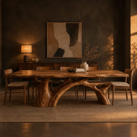 Rectangular dining table with a slab top and branching trunk base in a dark dining room at golden hour