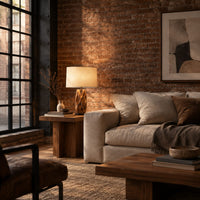 Branching wall sconce with open cutouts and a warm glow behind the wood in an industrial loft living room with exposed brick