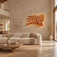Branching wall sconce shaped like coral with a warm glow behind its edges in a bright open plan living room