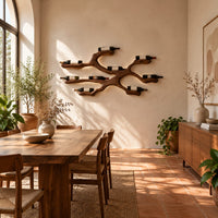 Branching wood wine bottle holder with a cradle at each branch tip in a bright dining room with arched windows and plants