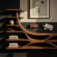 Corner detail of TV stand with branching floating shelves on a carved base beside wood, brass and linen samples