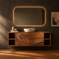 Floating vanity with carved breaking wave fronts and open cubbies at both ends in a dark studio against a charcoal plaster wall