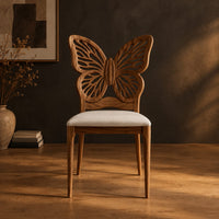 Chair with a pierced butterfly wing backrest and padded seat in a dark studio against a charcoal plaster wall