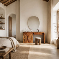 Desk style vanity with a butterfly carved cabinet and a single drawer in a bright open plan bedroom