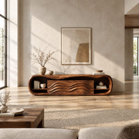 Capsule shaped tv stand with open end shelves and wave carved center panels in a bright open plan living room