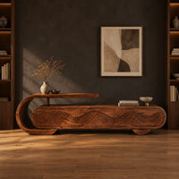 Capsule shaped tv stand with carved wave panels and a scroll end ledge in a dark studio against a charcoal plaster wall