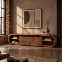 Low capsule shaped wooden tv stand with wave carved panels and open end shelves in an industrial loft living room with exposed brick