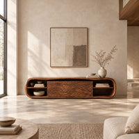 Low capsule shaped wooden tv stand with wave carved panels and open end shelves in a bright open plan living room