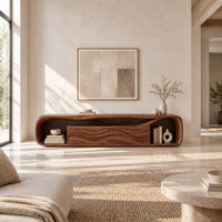 Capsule shaped media console with wave carved center panels and open end cubbies in a bright open plan living room