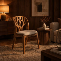 Wooden chair with a carved branch pattern back and a pale fabric seat in an evening living room with walnut wall paneling