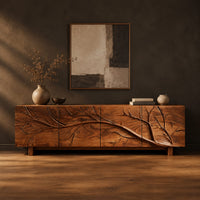 Tv stand with a carved branch relief across four front panels in a dark studio against a charcoal plaster wall
