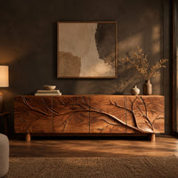 Tv stand with a carved branch relief across four front panels in a dark living room at golden hour
