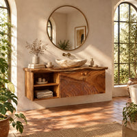 Floating cabinet with two carved contour doors and an open shelf bay in a bright bathroom with arched windows and plants
