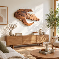 Carved crescent moon wall art with a bank of layered scalloped clouds in a bright sunroom with green plants