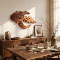 Carved crescent moon wall art with a bank of layered scalloped clouds beside a dining table in natural light