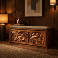 Shoe bench with two carved relief doors and a padded seat on top in an evening entryway with walnut wall paneling