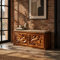 Shoe bench with two carved relief doors and a padded seat on top in an industrial loft entryway with exposed brick