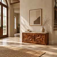 Shoe bench with two carved relief doors and a padded seat on top in a bright open plan entryway
