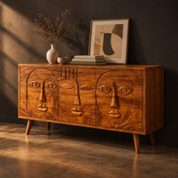Mid century sideboard with three carved faces and four tapered legs, three-quarter view showing the grain