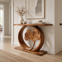 Console table with a carved fan leaf inside a circular frame in a Scandinavian entryway with white walls
