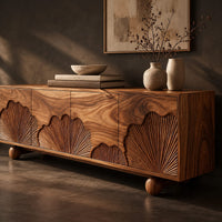 Corner detail of sideboard with carved fan motifs across four panels and ball feet beside wood, brass and linen samples